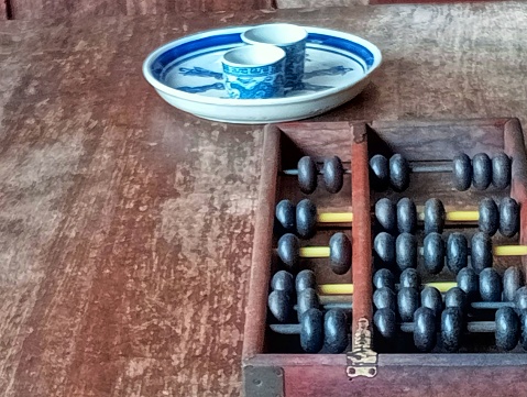 Antique wooden abacus and tea tray antique Chinese teacup.