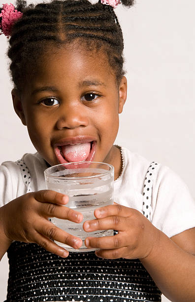 niña con un sabroso taza de agua - wasserglas fotografías e imágenes de stock