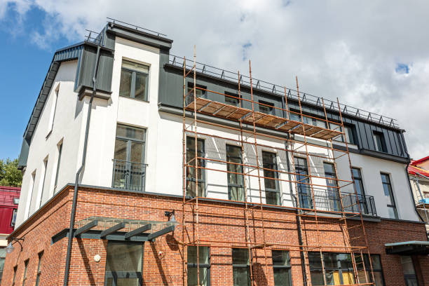 facade of the old building with construction scaffold against cloudy sky.
