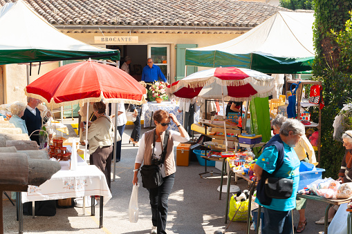 Saint Paul de Vence, Provence,  France -May 2 2011; Typical weekend flea market with patrons blurred in motion as they lood at offerings