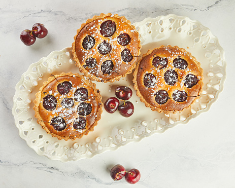 French Flair, Cherry Clafoutis Presented on White Marble. Mouthwatering Temptation: Clafoutis and Cherries on Marble.