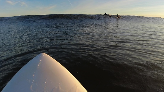 Surfer Paddling on Baltic Sea Waves at Sunrise POV Slow Motion