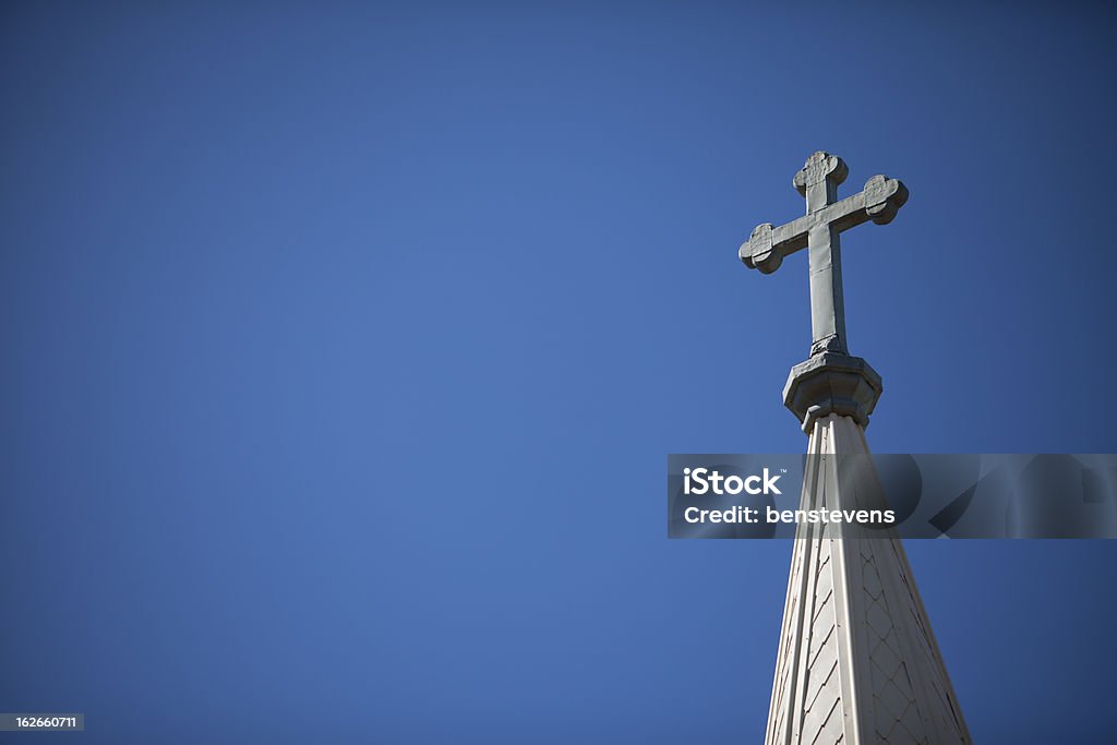 Church Steeple and Cross A Crucifix rises high above the skyline on top of a church's steeple. Church Stock Photo