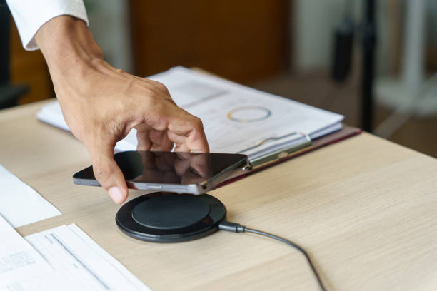 istock Charging mobile phone battery with wireless charging device in the table. Smartphone charging on a charging pad. Mobile phone near wireless charger Modern lifestyle technology concept 1626611389