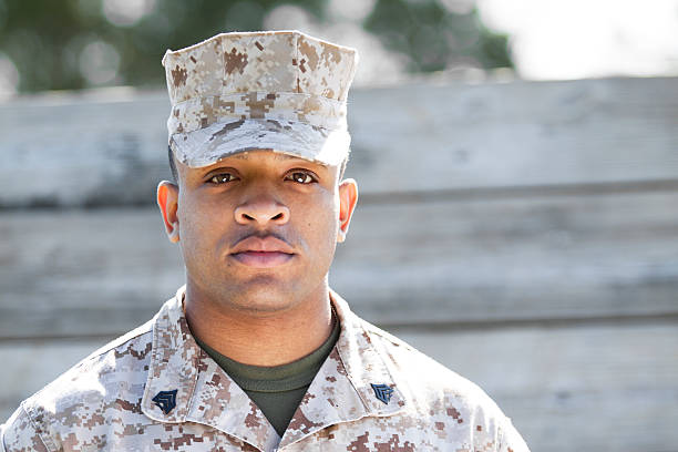 Marine at Obsyacle Course Marine standing in front of a wood wall at an obstacle course. black military man stock pictures, royalty-free photos & images