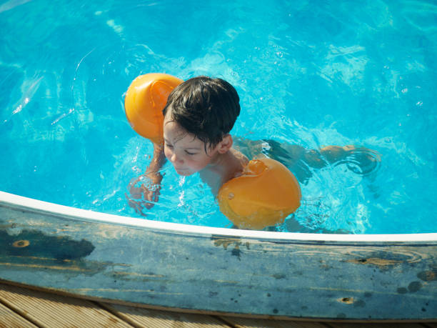 istock A Beautiful boy swims alone in the pool. 1626627083