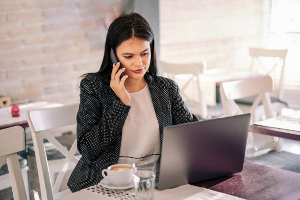 istock Young female freelancer talking on the phone in the cafe 1626641612