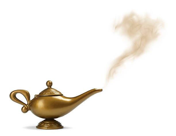 A golden genie lamp with smoke coming out stock photo