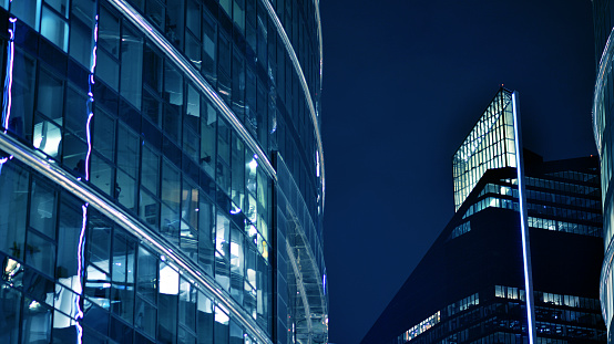 Glass architecture ,corporate building at night - business concept. Blue graphic filter.