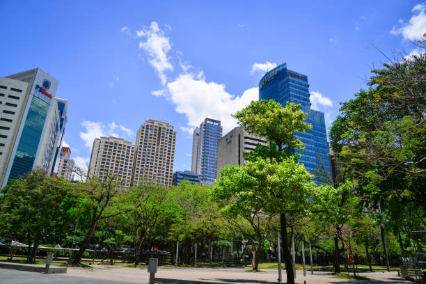 Manila, Philippines - Apr 14, 2017. Modern buildings with green tree park in Manila, Philippines. Manila is a major center for commerce, banking and finance in Philippines.
