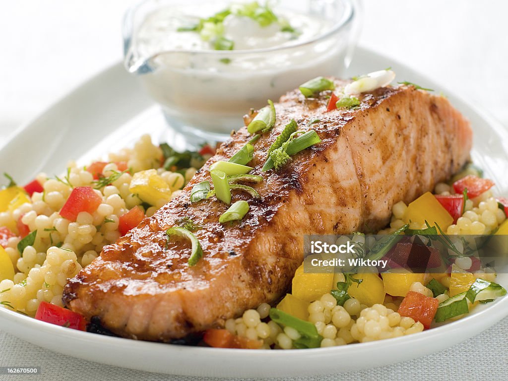 grilled salmon with couscous Grilled salmon with couscous  and sauce, selective focus Couscous Stock Photo