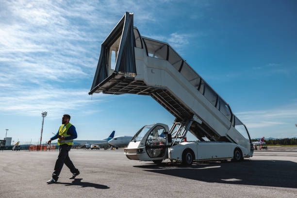 Airport worker walking under the towable stairs at the airport.