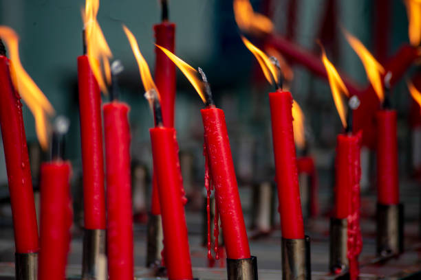 Red candles are lit for worship and blurred background.