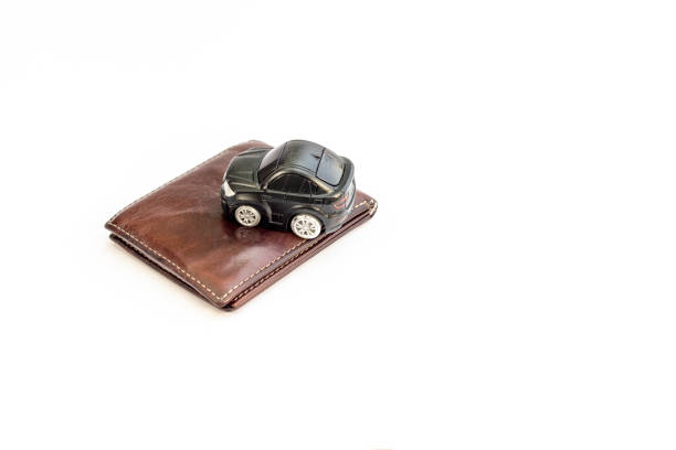 istock Toy car on wallet isolated white background. Car insurance or expense concept. 1626772006