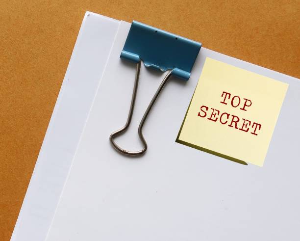 istock Note stick on office document written TOP SECRET concept of data or information intended to be kept confidential, something entrusted with secret affairs 1626776283