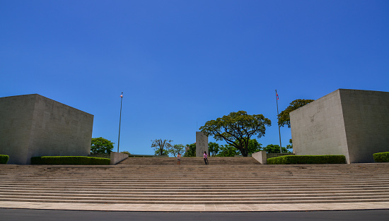 Manila, Philippines - Apr 14, 2017. Manila American Cemetery headstones with memorial building behind. Cemetery is located in Fort Bonifacio, in Taguig City, Manila.