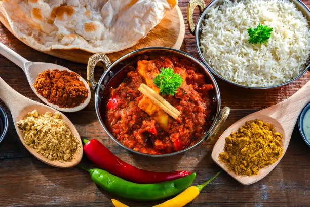 Composition with indian madras paneer with basmati rice served in original indian karahi pots.