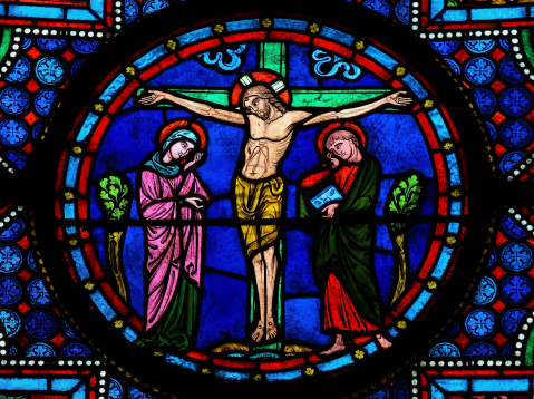 Stained glass window depicting Jesus on the Cross in the cathedral of Bayeux, Normandy, France. This window was created in the 15th century, no property release is required.