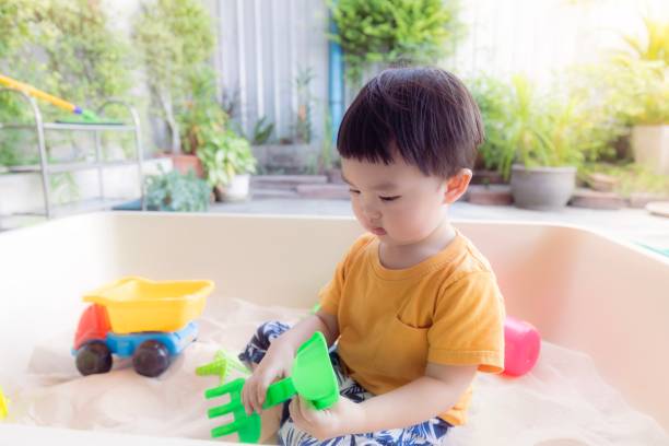 istock Kid is playing toy in sandbox 1626816815