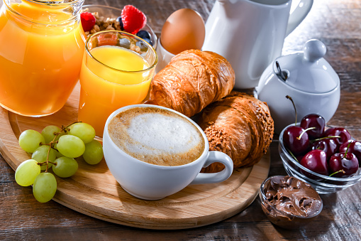 Breakfast served with coffee, orange juice, croissants and egg.