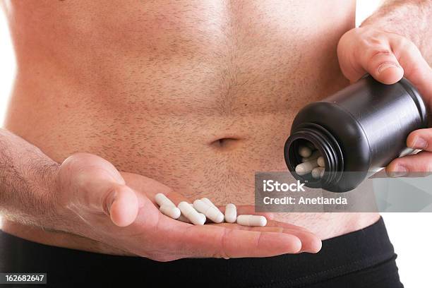 Hombre Mano Completa De Comprimidos O Comprimidos Caja Con Complementos Foto de stock y más banco de imágenes de Abdomen