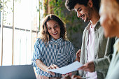 A Happy Beautiful Blonde Woman Explaining Some Document To Her Colleague