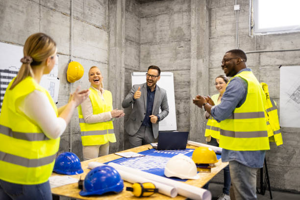 istock Motivated and positive people at construction site meeting laughing and clapping hands. 1626863543
