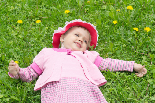Top view of a sweet little girl relaxing on the grass