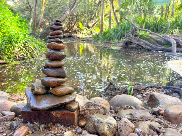 istock Rock stack Cairn built on the river bank edge.  Rocks in the front.  River water, greenery in the background. Gold Coast Queensland Australia 1626870549