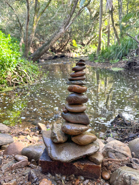 istock Rock stack Cairn built on the river bank edge.  Rocks in the front.  River water, greenery in the background. Gold Coast Queensland Australia 1626870558