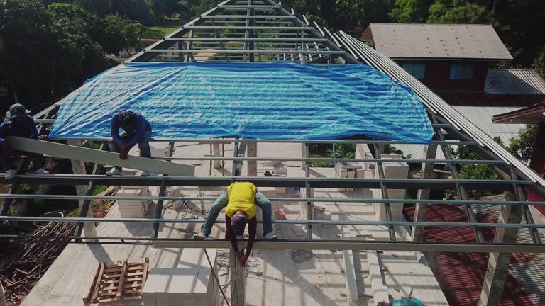 Aerial drone shot of roofers work on the roof.