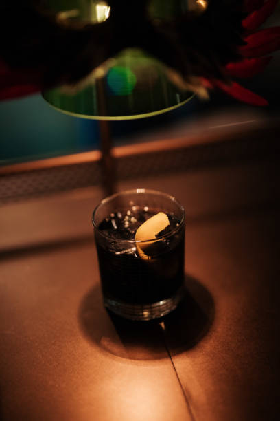 istock Old Fashioned Cocktail With Lemon Garnish On Dark Lit Bar Counter 1626888371