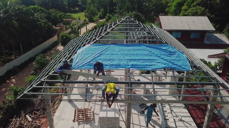 Aerial drone shot of roofers work on the roof.