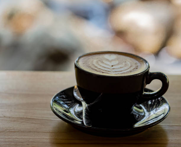 istock Hot coffee in black cup and blurred nature background. 1626895185