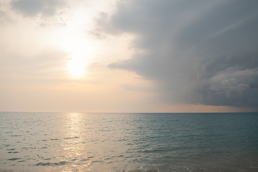 picturesque scenery of seascape in evening time, There are the sun and rain clouds in the orange sky, Phuket, Thailand,