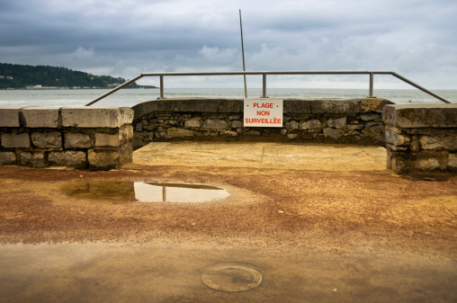 Hendaye beach in Pays Basque (France) on a cloudy day. A sign saying in french 