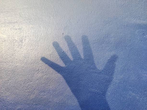 istock hand silhouette background on blue wall. news illustration concept about asking for help in cases of violence 1626909455