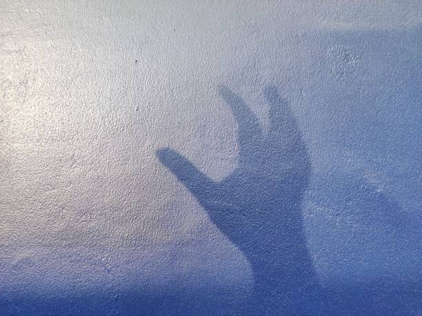 istock hand silhouette background on blue wall. news illustration concept about asking for help in cases of violence 1626910549