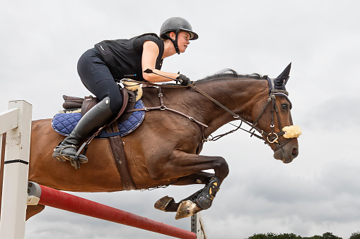 A female show jumper on her brown mare is crossing over a hurdle on a cloudy day during a horse riding work shop at Ranshofen Horse Riding Arena, Austria.
Canon EOS 5D Mark IV, 1/1250, f/8, 16 mm.
