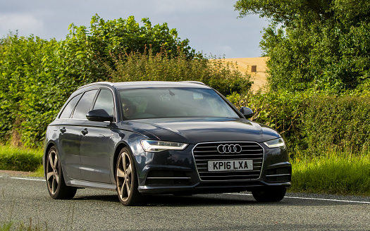 Woburn, Beds, UK - Aug 19th 2023: 2016 blue diesel engine Audi A6 car travelling on an English country road.