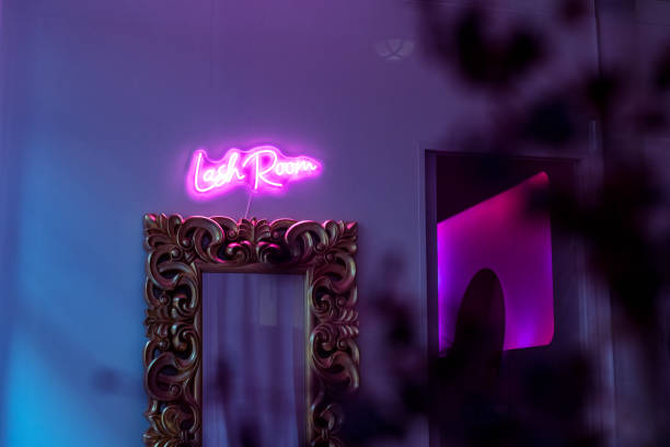 A neon sign in a dimly lit room reads Lash Room.
