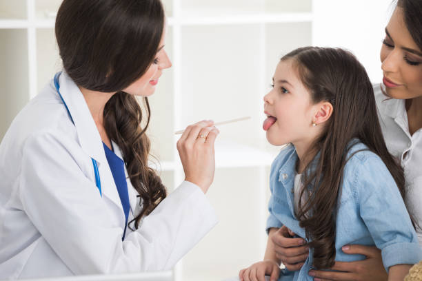 istock Doctor examine child's throat 1626993319