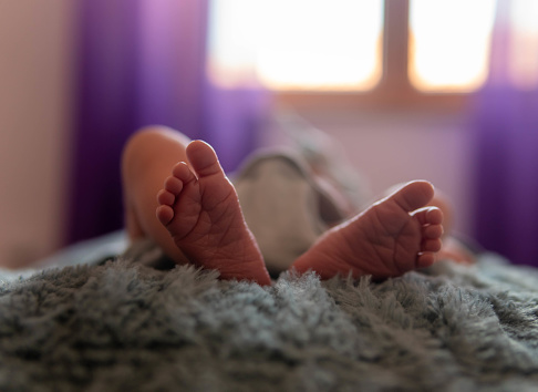 Foot of newborn on cozy blanket