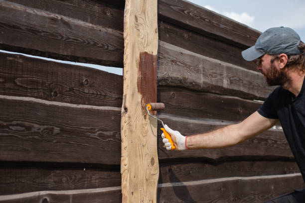 istock A man builds and paints a fence from rough boards 1627040504