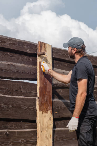istock A man builds and paints a fence from rough boards 1627040942