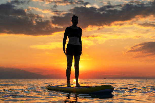 istock standing on SUP against the backdrop of a stunning sunset 1627044815