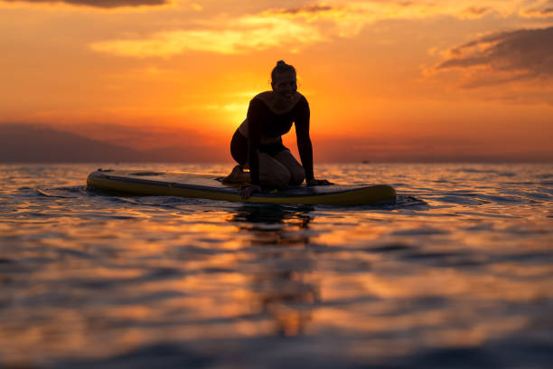 istock sitting on SUP against the backdrop of a stunning sunset 1627045372