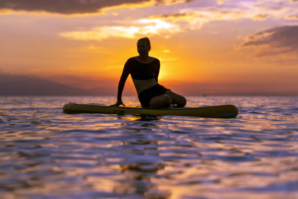 istock sitting on SUP against the backdrop of a stunning sunset 1627045986