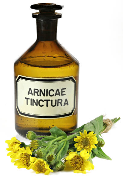 apothekenflasche mit arnika-tinktur - medicine flower group of objects dilution stock-fotos und bilder