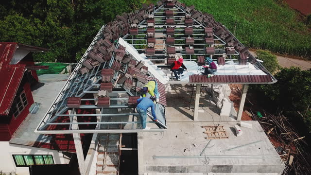 Aerial drone shot of roofers work on the roof.